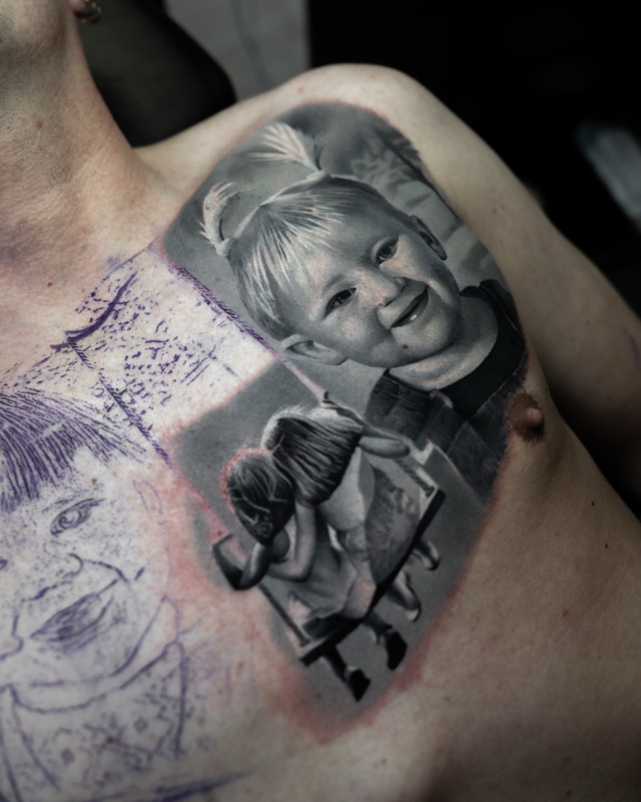 Realistic black and grey baby portrait tattoo